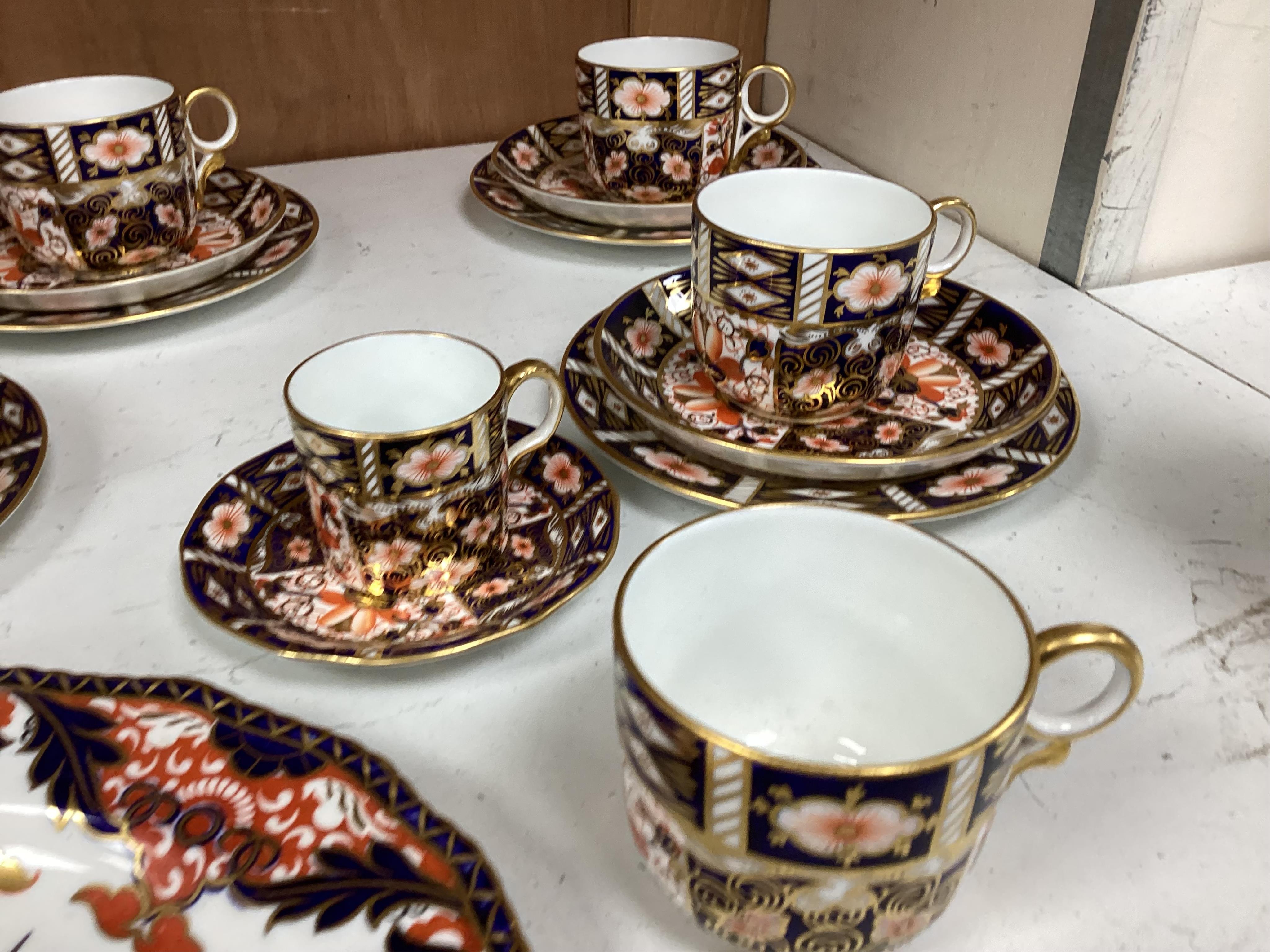 A Crown Derby Imari seven trio place setting, three other cups and two saucers, a large plate and a pair of Doccia- style vases, 18cm high